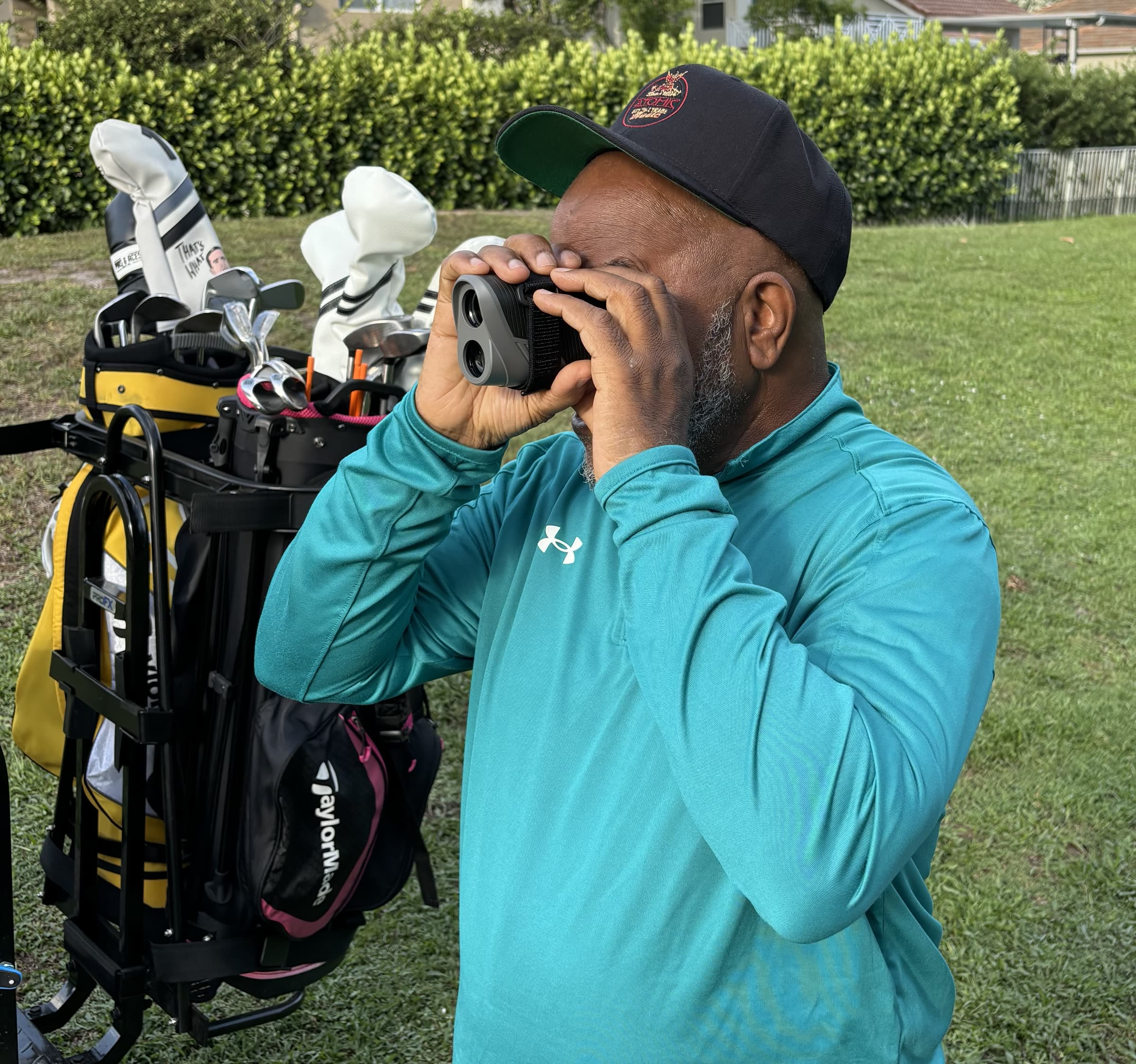 Bill Pettaway using a rangefinder on a golf course